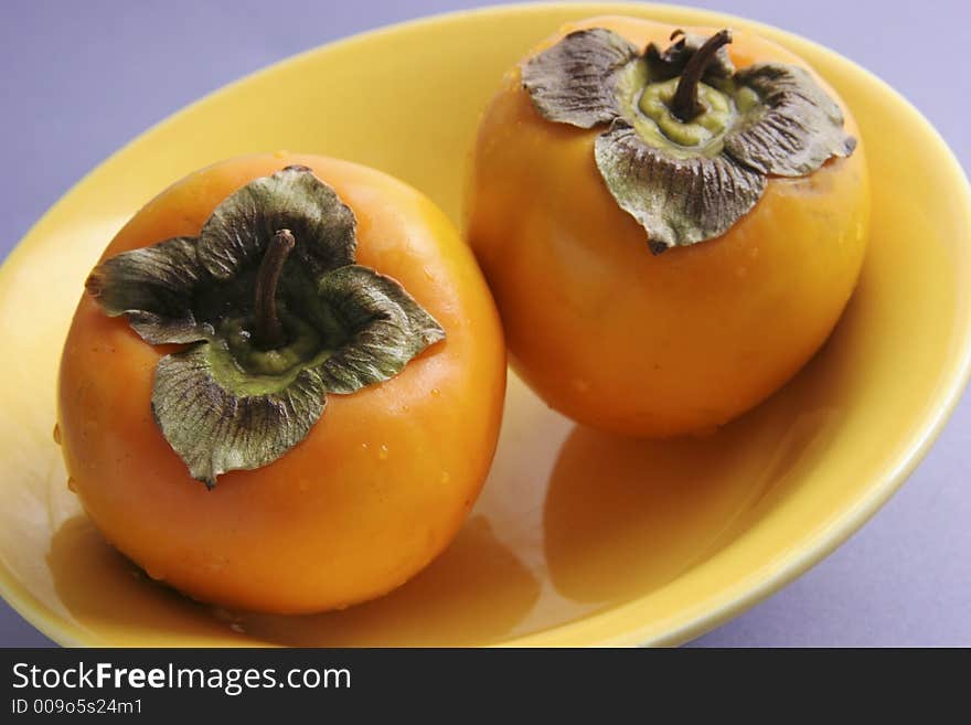 Two persimmons on a white background. Two persimmons on a white background.