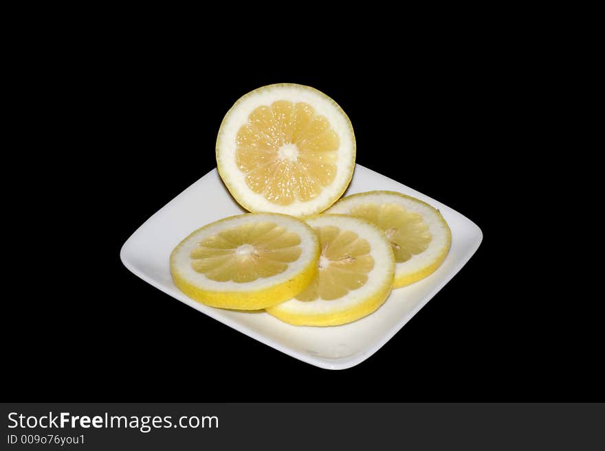 An isolated plate of sliced lemons. An isolated plate of sliced lemons