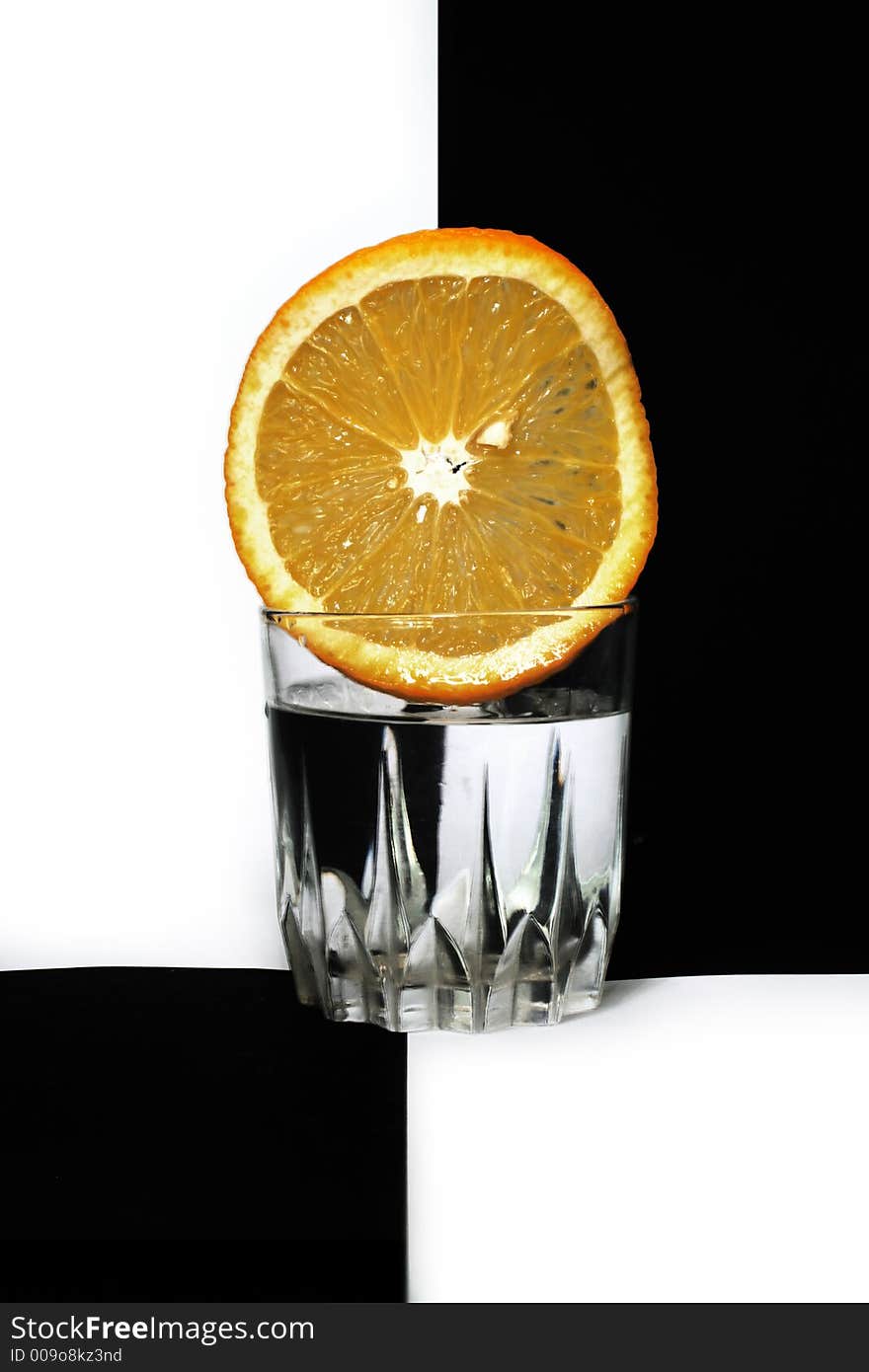 A glass almost full of water, and an orange in it. A glass almost full of water, and an orange in it.