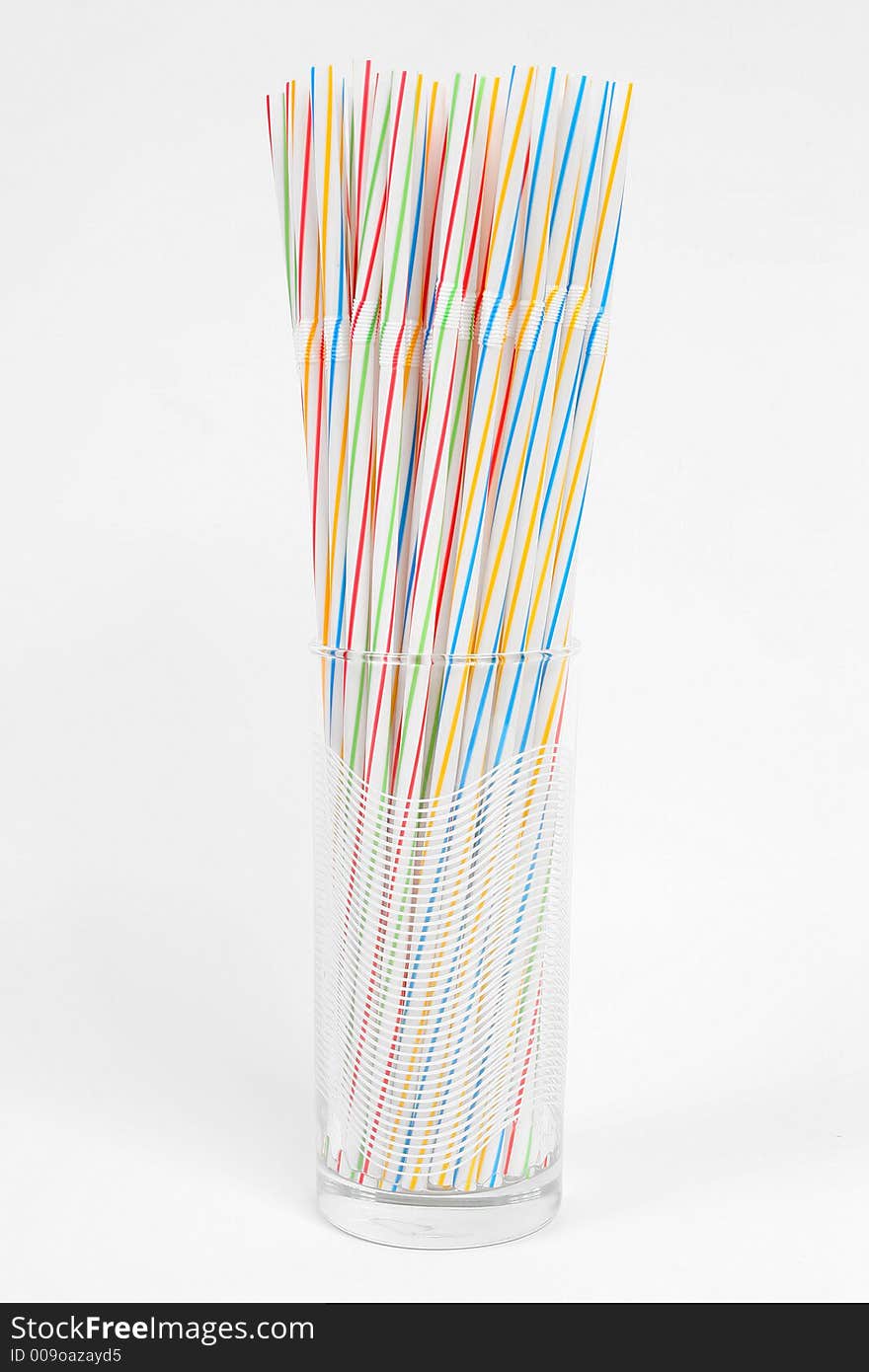 Assortment of colorful straws in a white glass