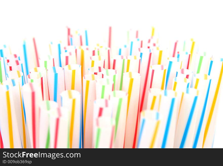 Assortment of colorful straws in a white glass