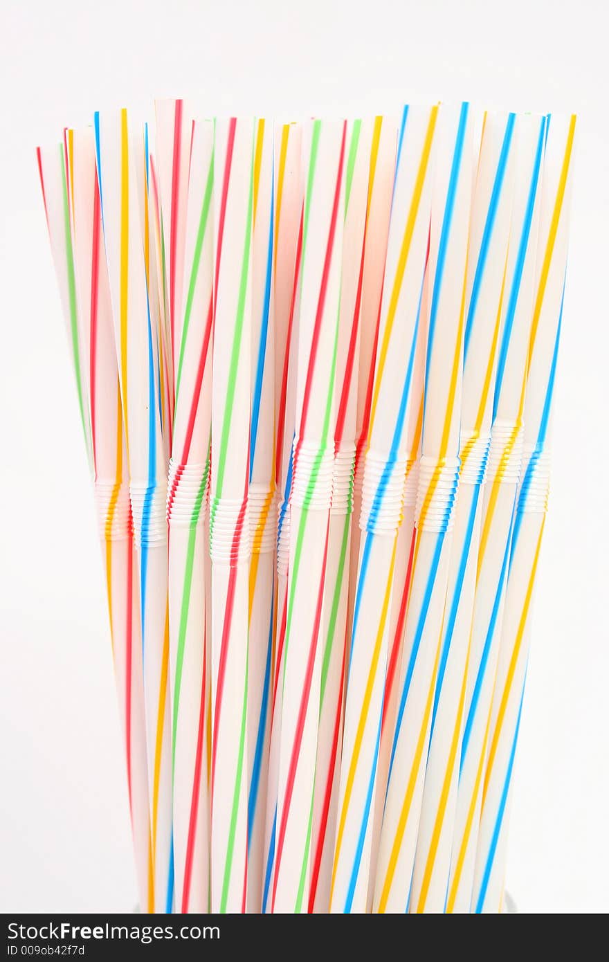 Assortment of colorful straws in a white glass