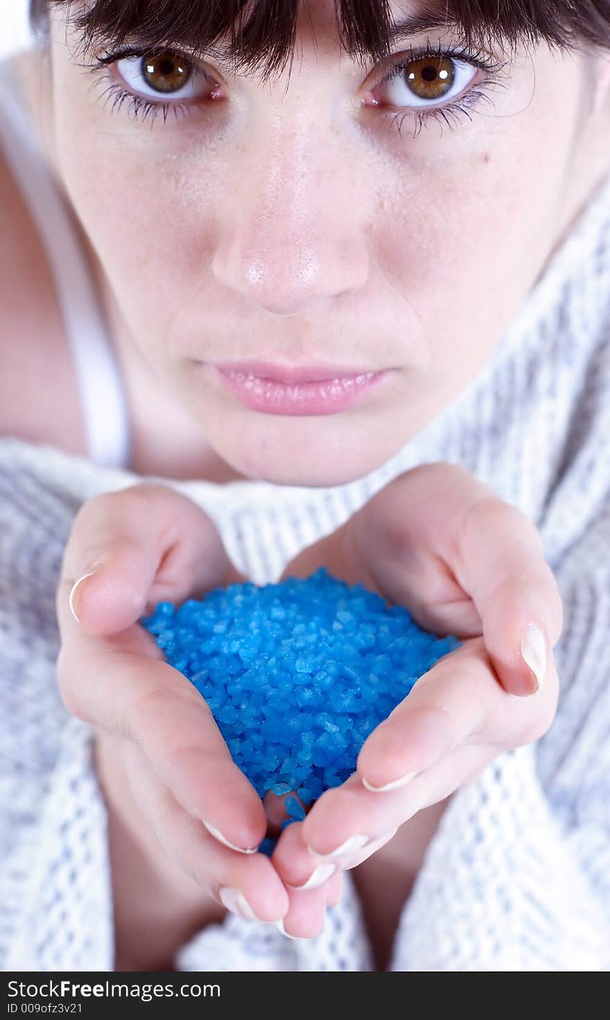 Stock photo of a young woman holding blue bath salt