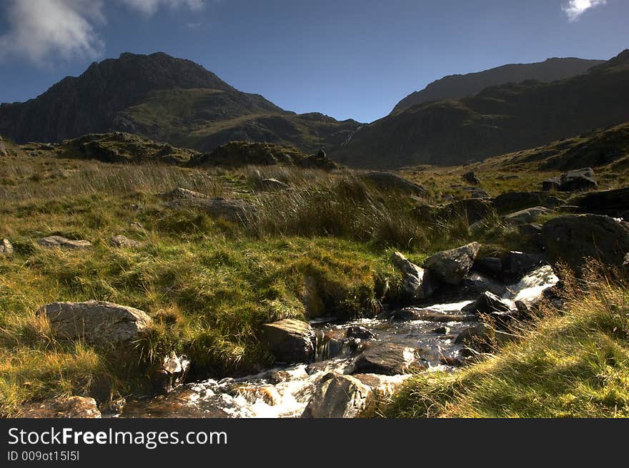 A mountain stream blocks the path upto Llyn Idwal, the Gribin Facet dominates the background.