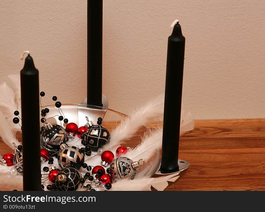 A black and white christmas decoration, with black candles and red balls. A black and white christmas decoration, with black candles and red balls