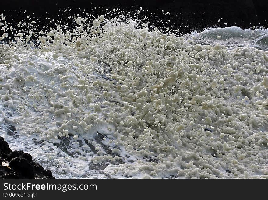 Sea foam flying off of a wild wave.