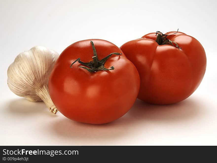 Fresh tomatoes and garlic on white background. Fresh tomatoes and garlic on white background