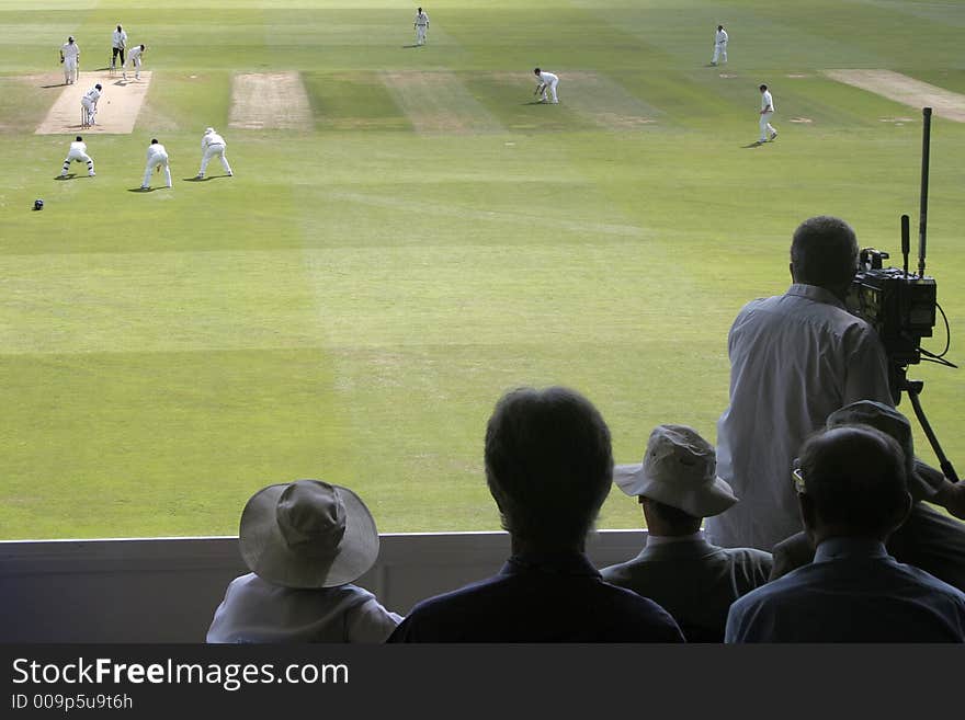 Spectators and cameraman follow the action at first-class cricket match. Spectators and cameraman follow the action at first-class cricket match