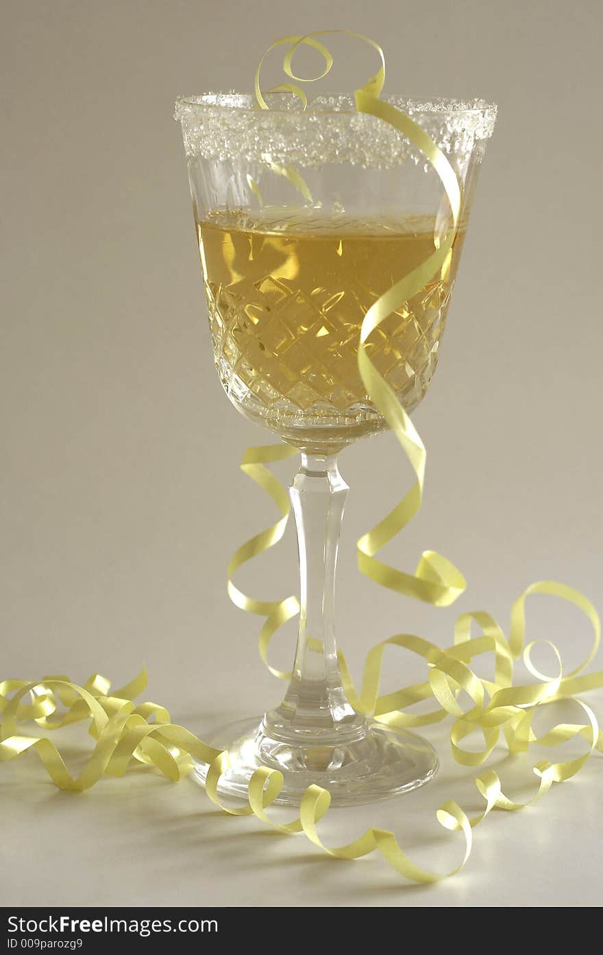 Champagne glass with yellow ribbon and white background