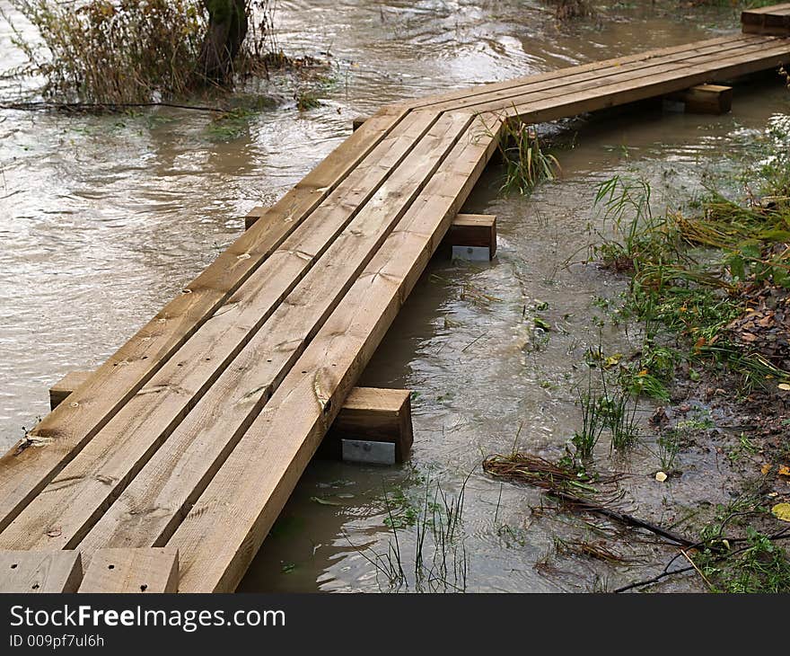 Wooden bridge through flooded river