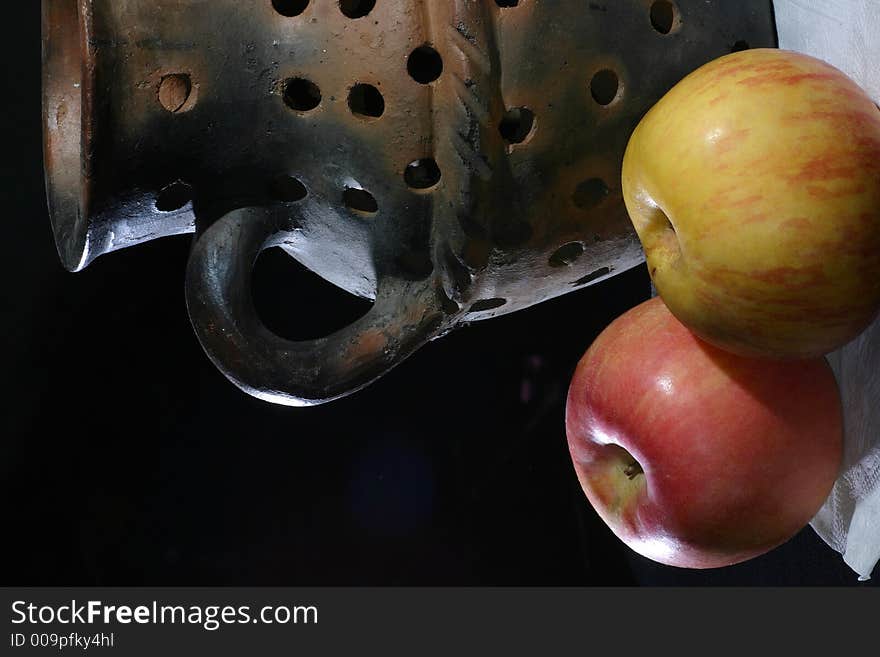 A pottery vase with a couple of apple. A pottery vase with a couple of apple