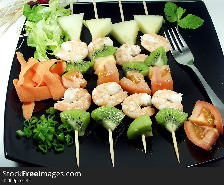 Shrimps snacks served on a black platter whit decoration