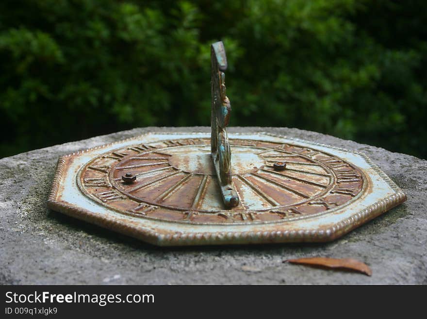 Close up of an old sundial found in a lush garden