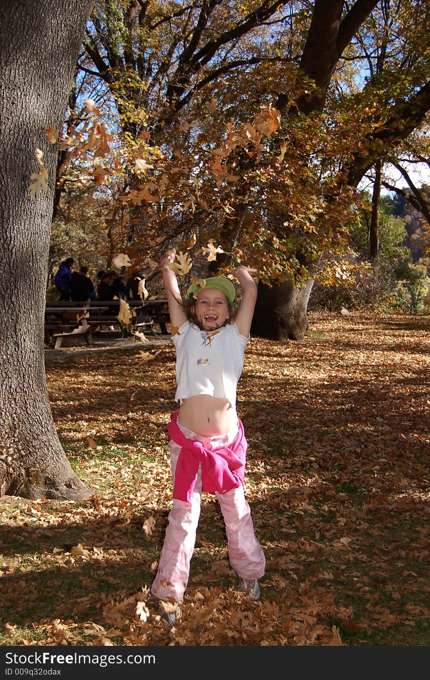 Nine year old girl tossing up leaves. Nine year old girl tossing up leaves.