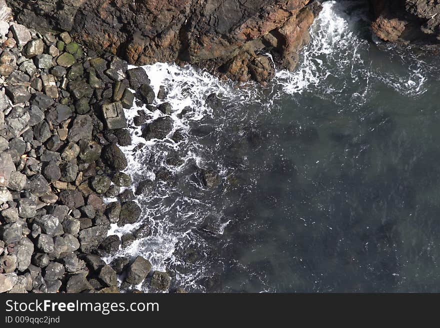 Surf and stones - solid an a rock - landscape format