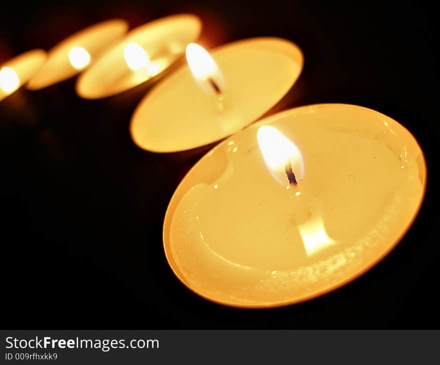 A row of candles over black background