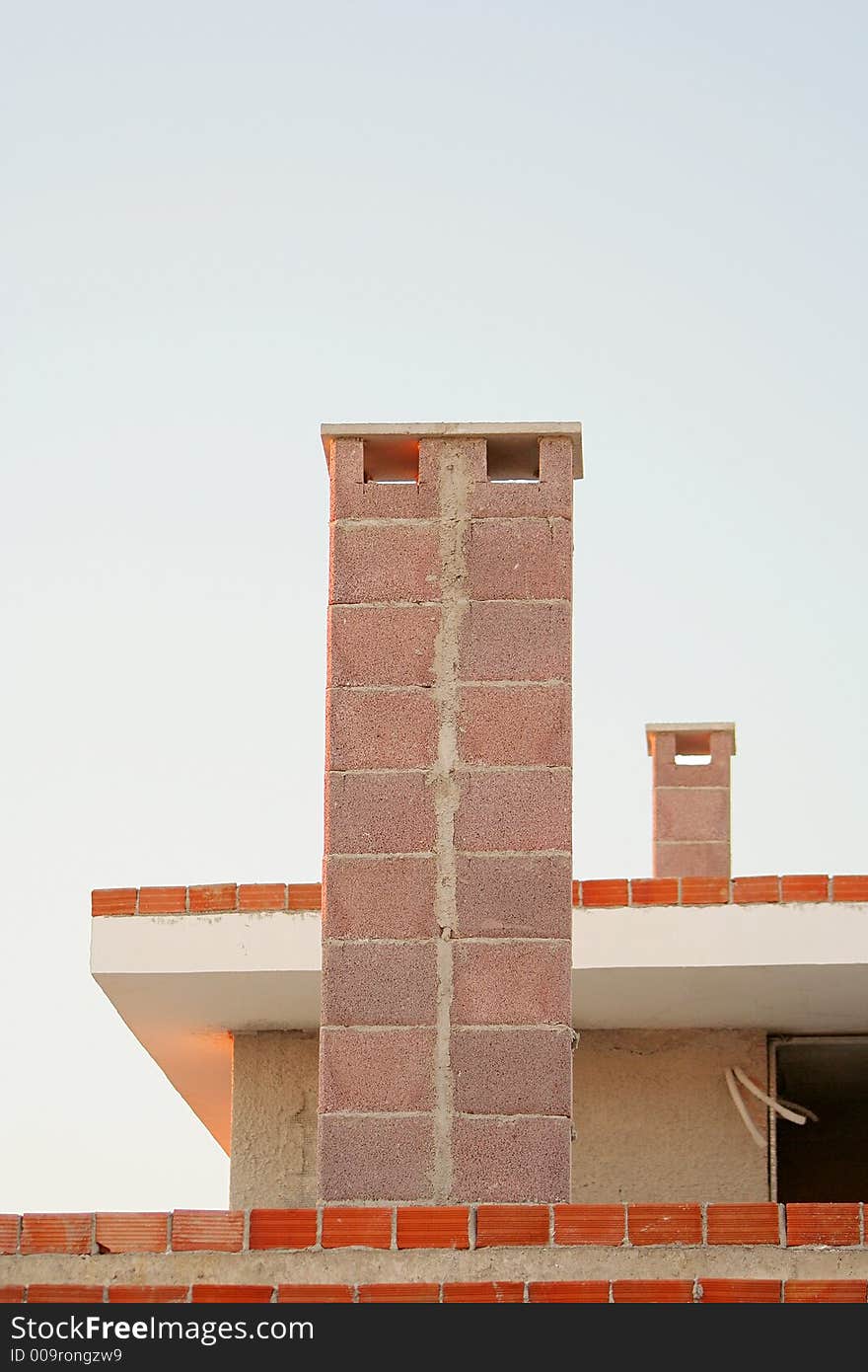 Two chimneys on the roof of a block of apartments. Two chimneys on the roof of a block of apartments