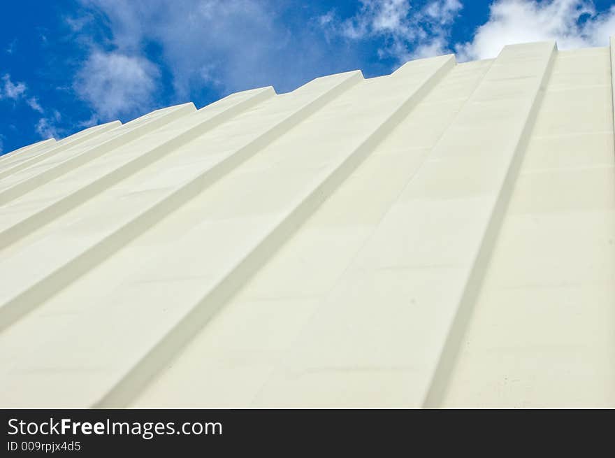 Corrugated iron roof against cloudy sky