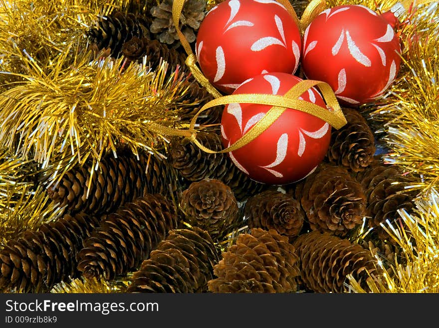 Christmas tinsel, three christmas balls, fir cones