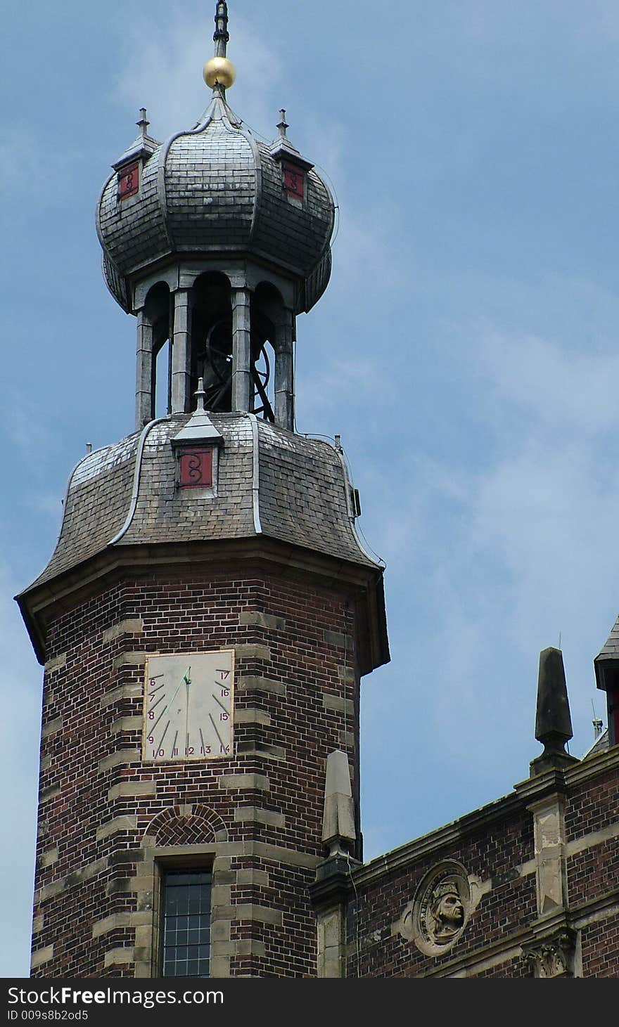 A clock tower with a sun-dial clock. A clock tower with a sun-dial clock