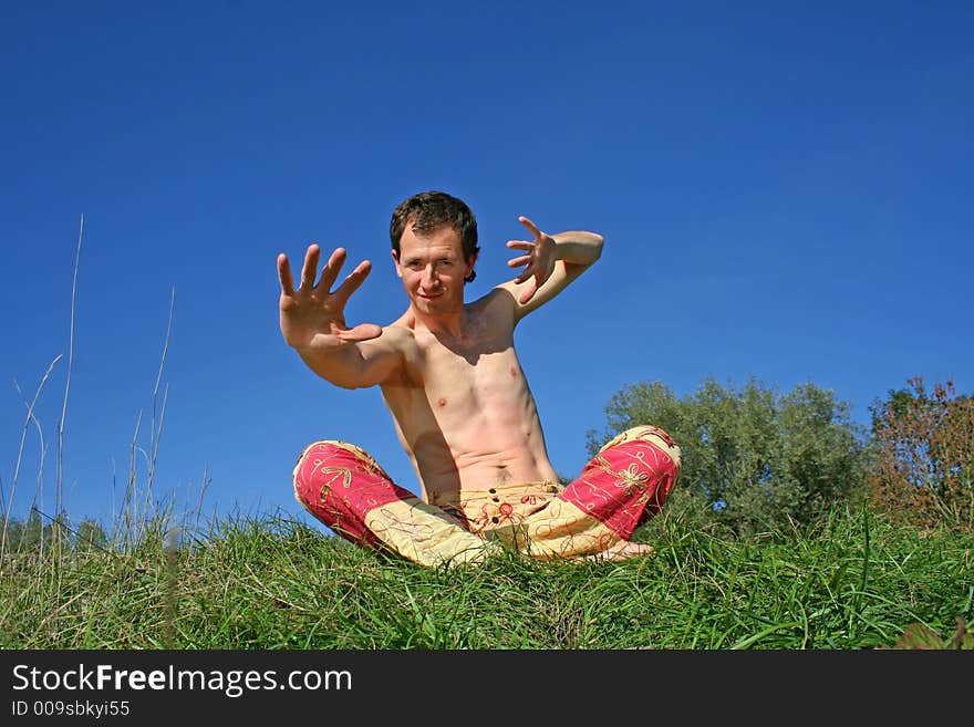 Man making arms gestures sitting in park. Man making arms gestures sitting in park