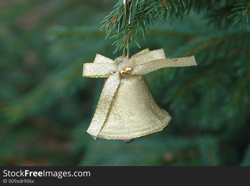 A golden bel hanging from branch