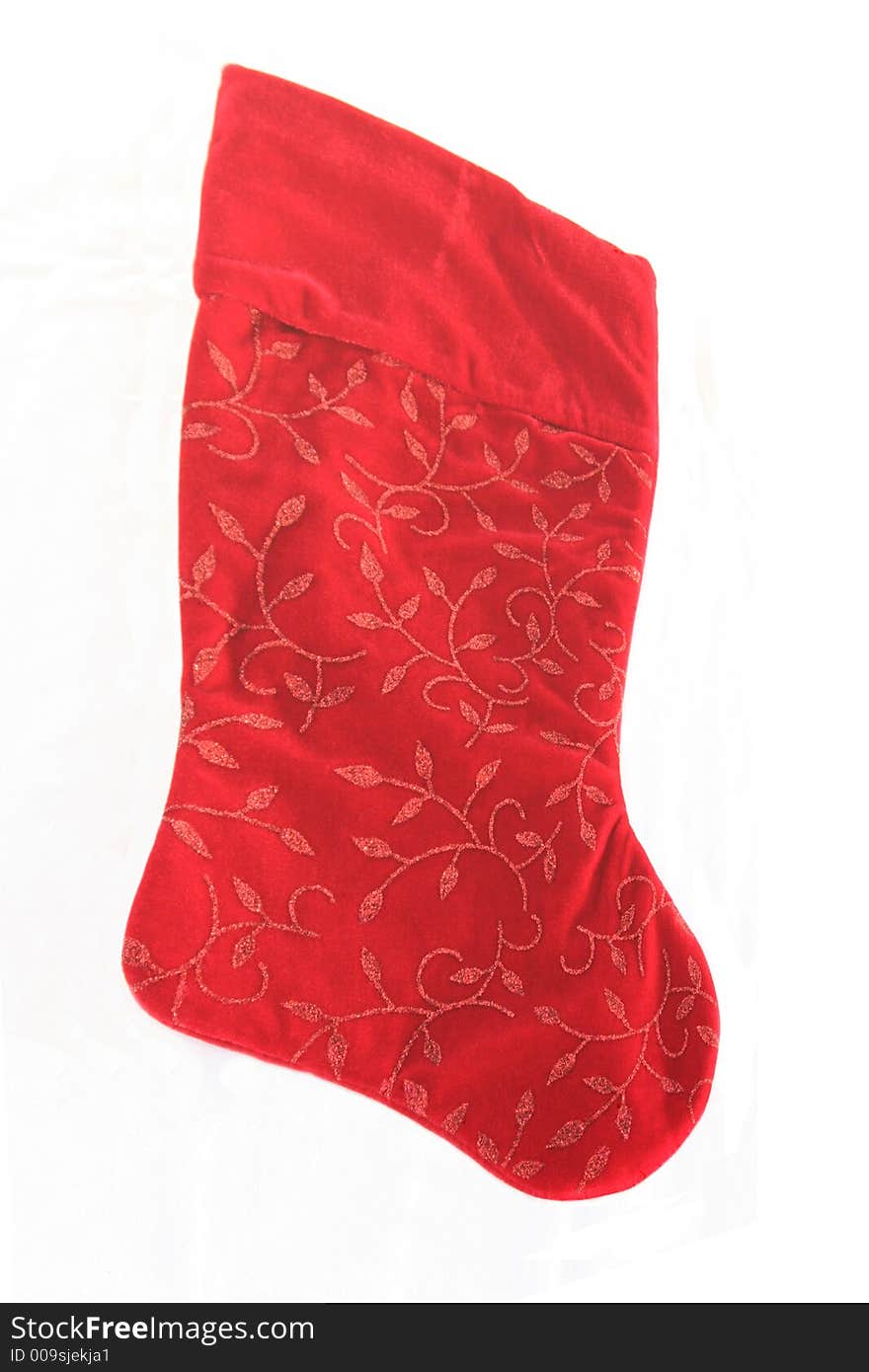 An isolated red Christmas stocking with a glitter design.