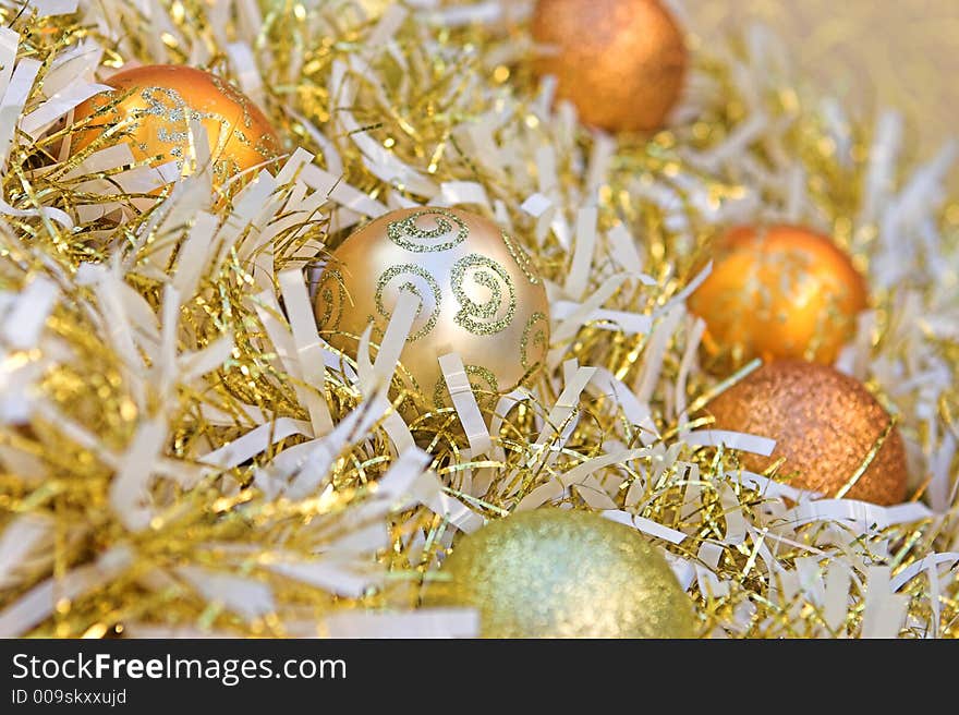 Christmas baubles nestled amongst gold & white tinsel. Christmas baubles nestled amongst gold & white tinsel