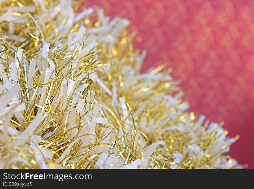 Christmas tinsel against a red background. Christmas tinsel against a red background