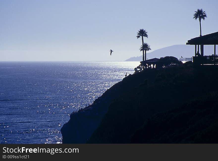 Silhouette of a tropical hut on a cliff overlooking the ocean. Silhouette of a tropical hut on a cliff overlooking the ocean.