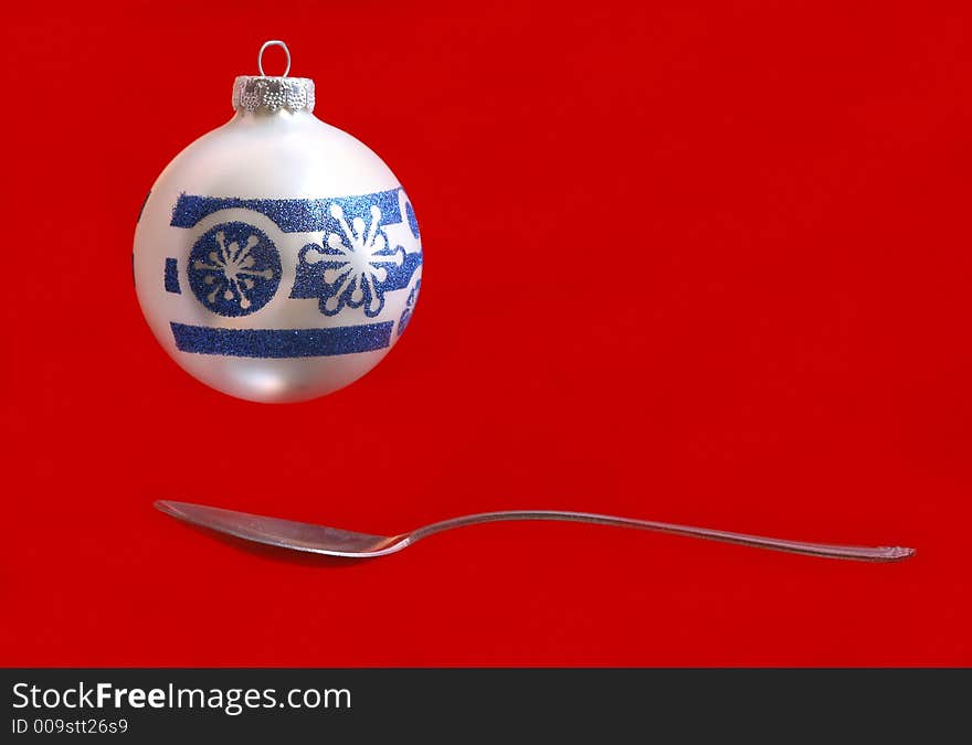 A Christmas ornament over a spoon. A Christmas ornament over a spoon