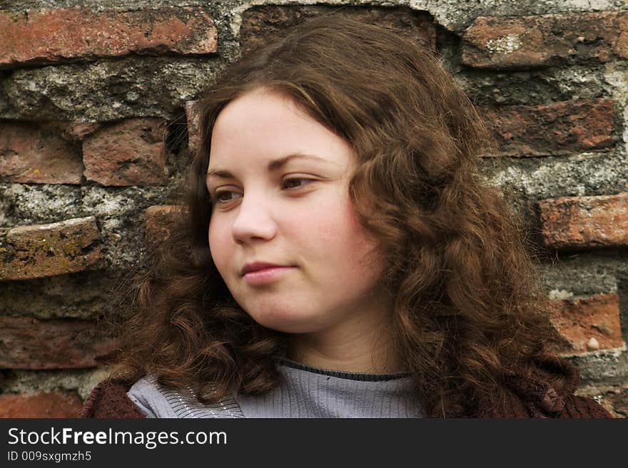 Lonley women dreaming near old red brick walls. Lonley women dreaming near old red brick walls