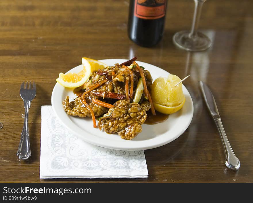 Shoot of glazed tempura orange beef with wine background. viewed from eater point of view. Shoot of glazed tempura orange beef with wine background. viewed from eater point of view