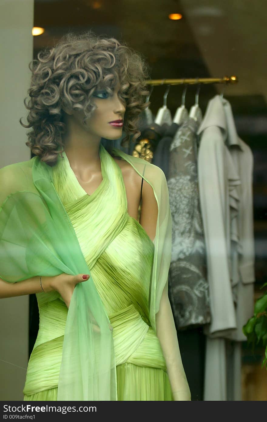 Doll in a green dress in a show-window of shop. Doll in a green dress in a show-window of shop