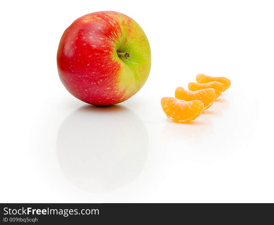 Composition made from apple and pieces of mandarins on isolated white background. Composition made from apple and pieces of mandarins on isolated white background