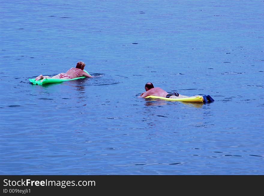 Woman and men floating on the sea at beach. Woman and men floating on the sea at beach