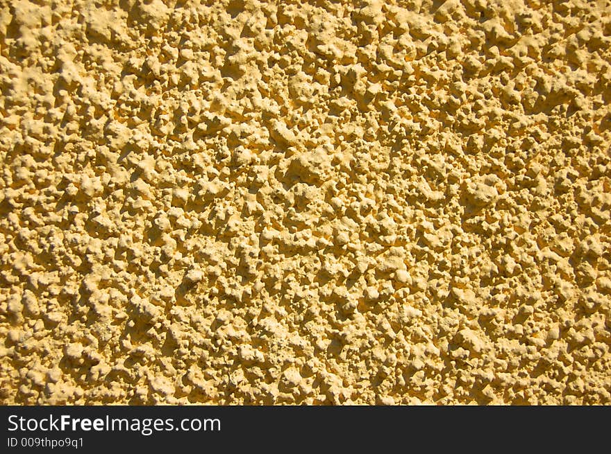 Yellow plaster texture from near house