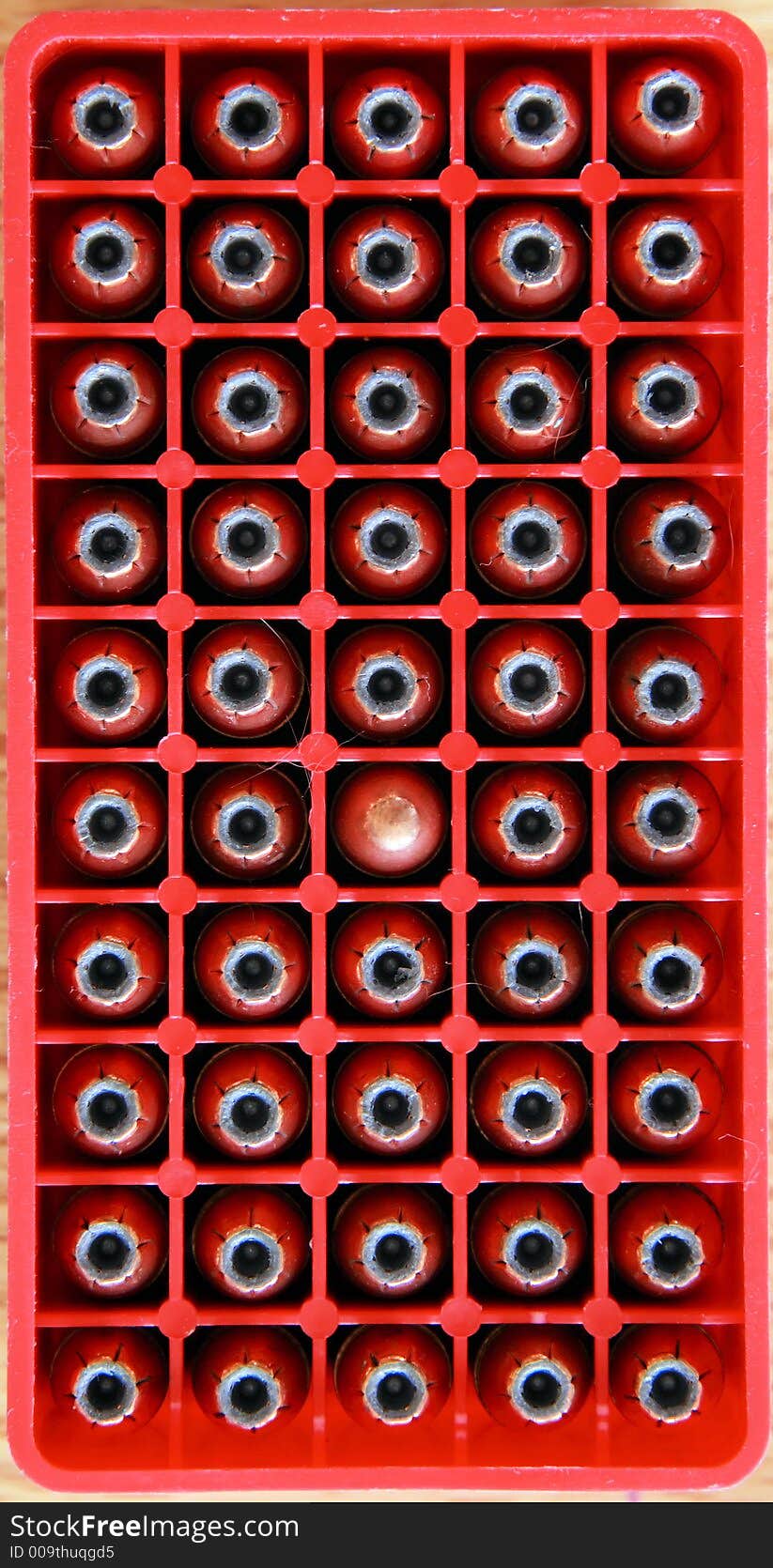 A box of 9mm bullets with one different.