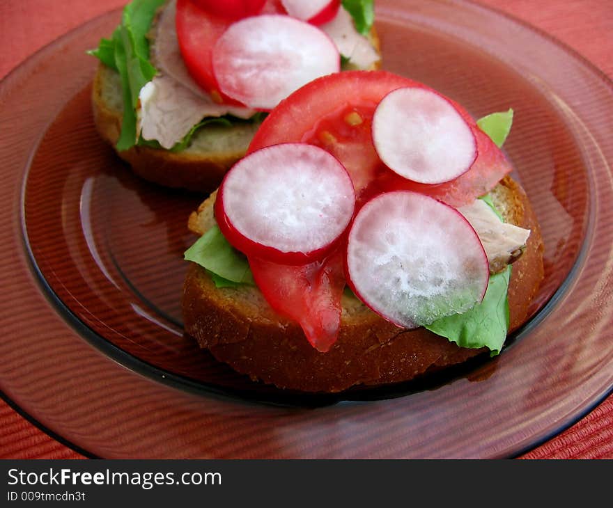 Fresh spring time sandwiches: bread, butter, lettuce, pork, tomato, radish