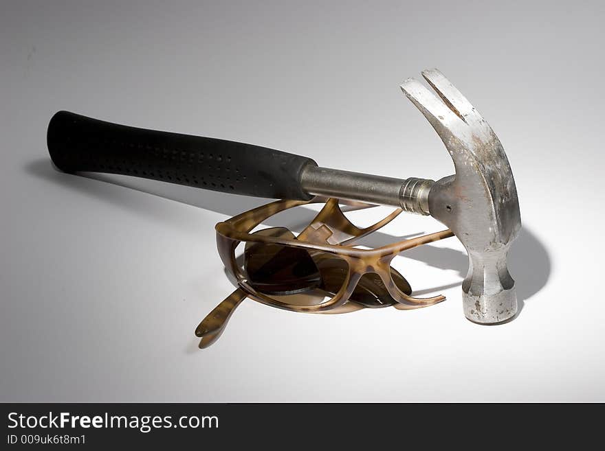 Photo of a Broken Sunglasses and Hammer. Photo of a Broken Sunglasses and Hammer