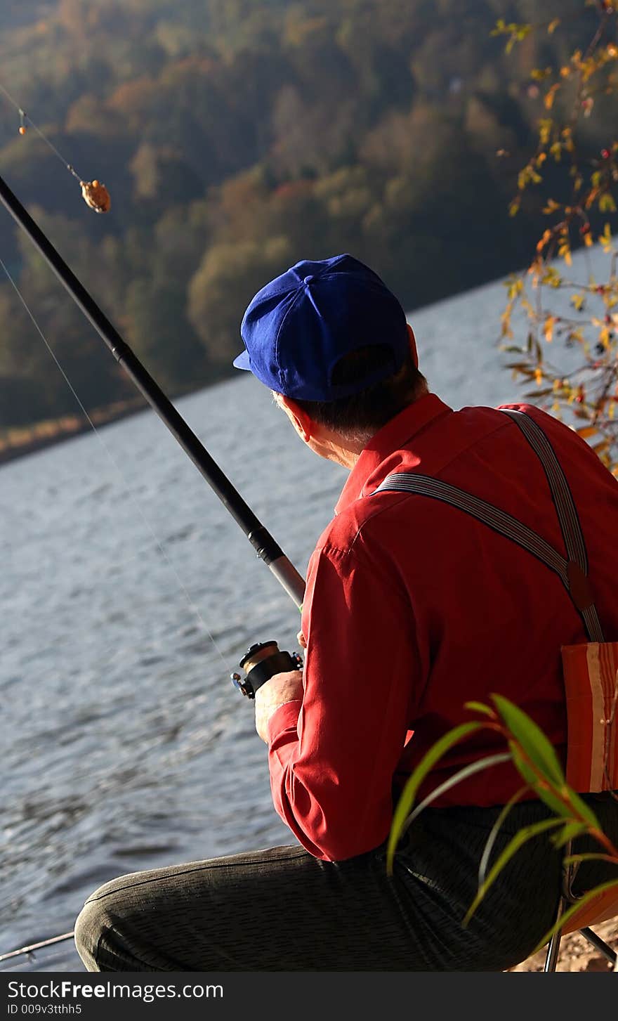 A fisherman looking at the bait, considering its size. A fisherman looking at the bait, considering its size