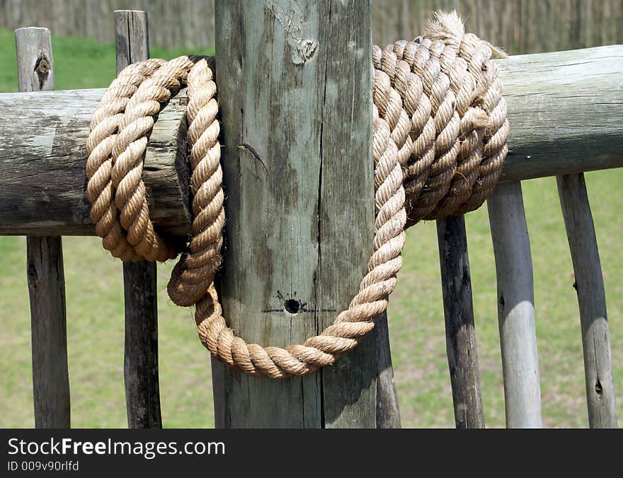 Thick rope securing a wood fence. Thick rope securing a wood fence