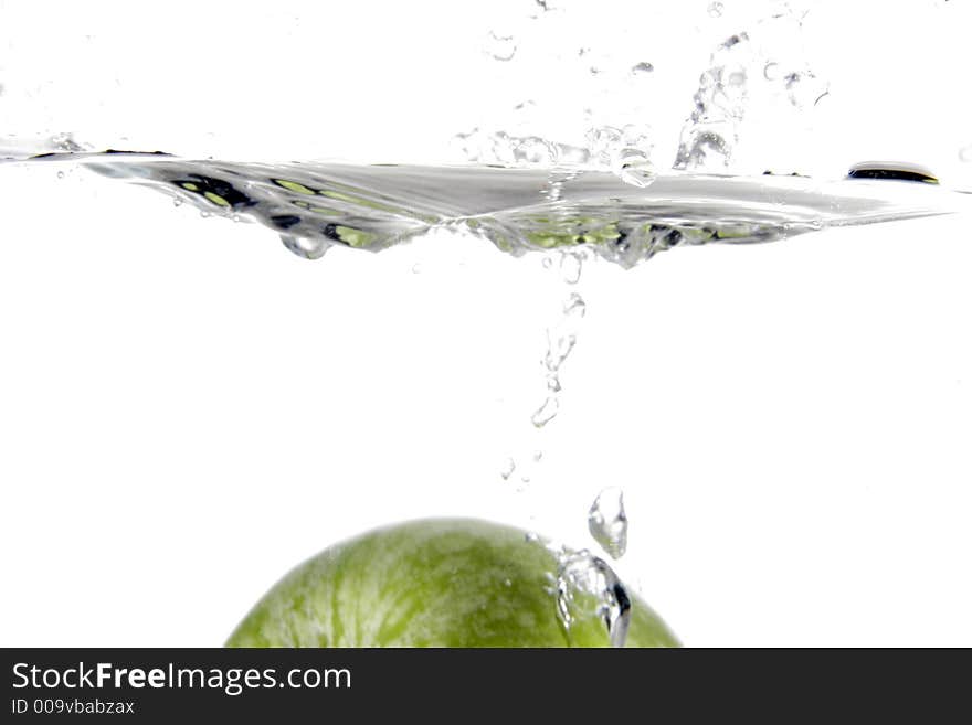 Green apple splashing into water. Green apple splashing into water