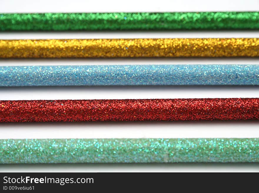 Five celebratory color pencils with a sparkling covering macro