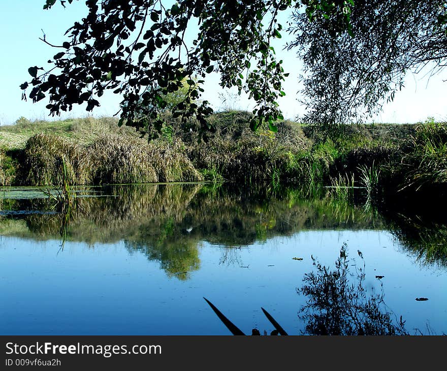 Ruffled surface of blue lake with branches from above, autumn 2006 year