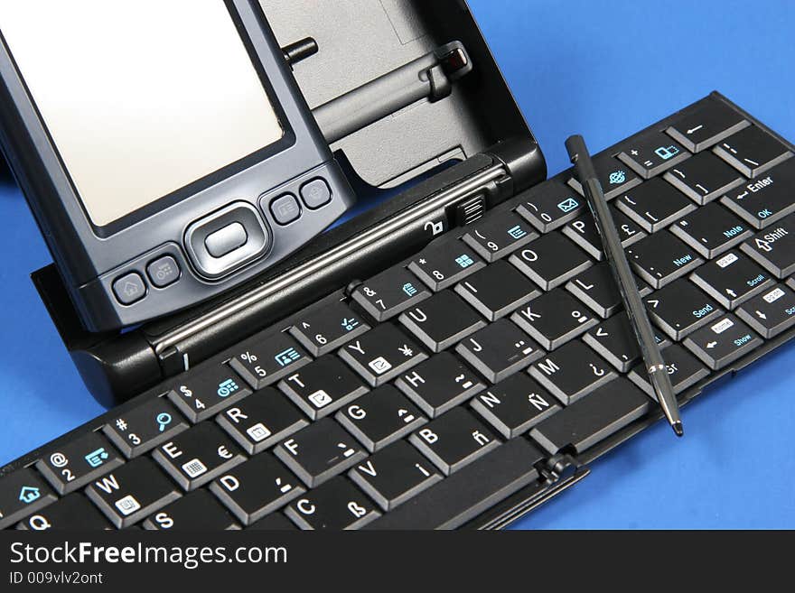 PDA and keyboard on blue background