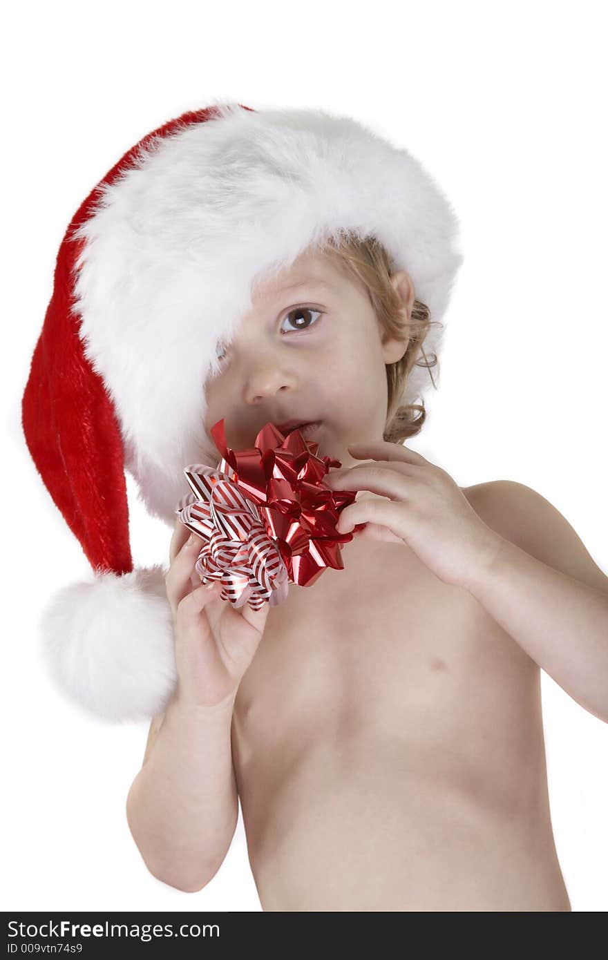 A young child wearing a santa hat and holding two christmas bows. Looking at the camera. Isolated white background. A young child wearing a santa hat and holding two christmas bows. Looking at the camera. Isolated white background