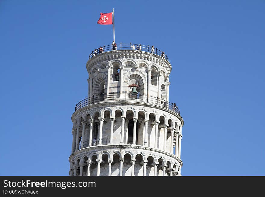 The top of tower of pisa with tourists and flag on they top. The top of tower of pisa with tourists and flag on they top