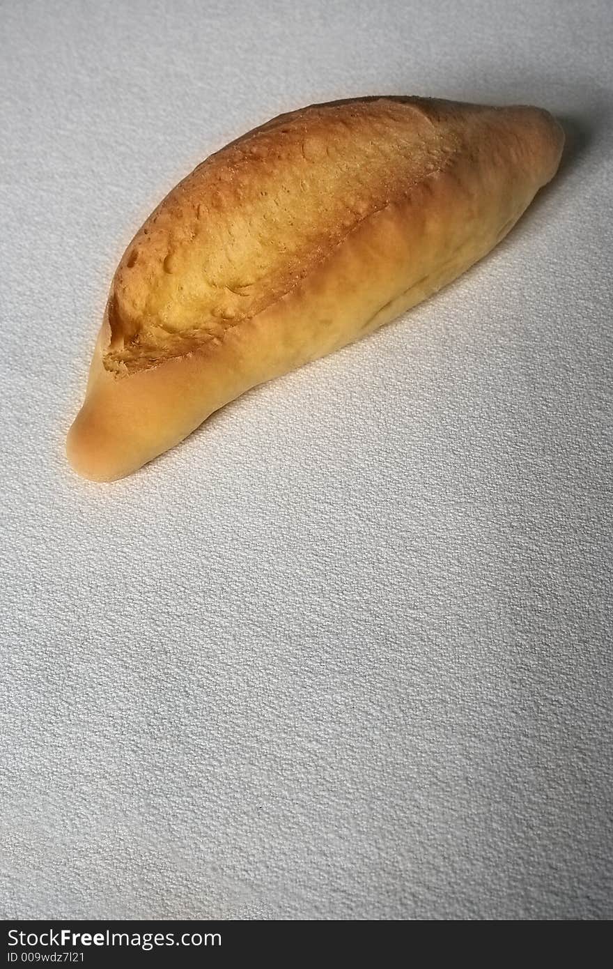 Piece of bread over white table cloth