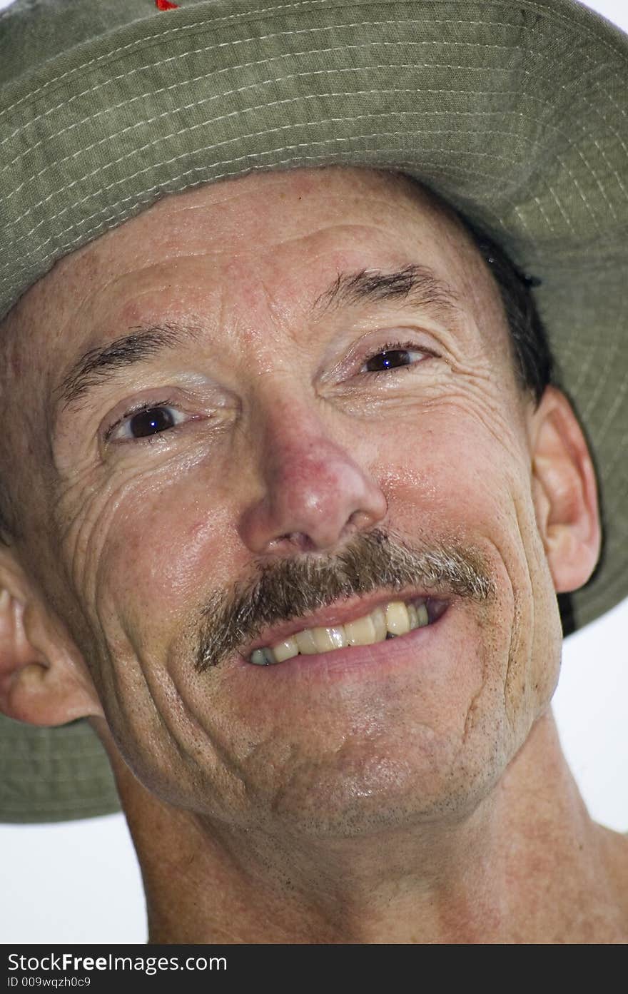 Man looking at camera and smiling while wearing a hat. Man looking at camera and smiling while wearing a hat